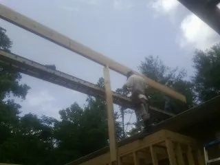 Carpenter setting a ridge beam over a new addition frame — Ice Dam Removal by Roofing Brothers in Orange