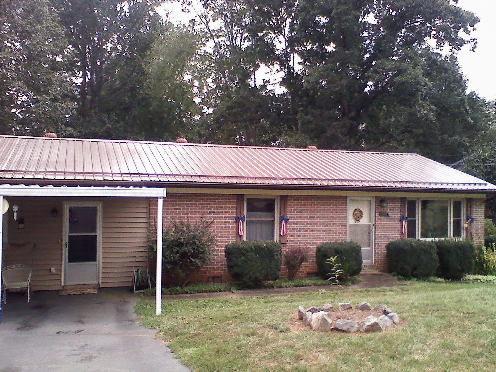 Bronze metal roof and carport on a brick ranch home — Roof Repair work by our crew in Orange